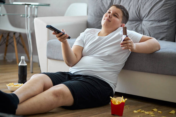 an overweight child boy enjoy leading unhealthy passive lifestyle - Foto, afbeelding