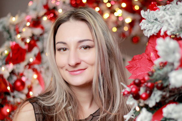 Πορτρέτο της νεαρής όμορφης γυναίκας στο δωμάτιο με εορταστική Χριστουγεννιάτικη ατμόσφαιρα - Φωτογραφία, εικόνα
