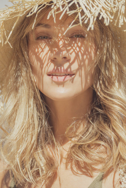 blank blond vrouw dragen stro hoed op een zomerdag, strand mode stijl - Foto, afbeelding