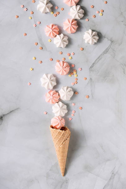 Pose créative à plat, vue de dessus avec cône de gaufre à la crème glacée et guimauves sur table en marbre. - Photo, image
