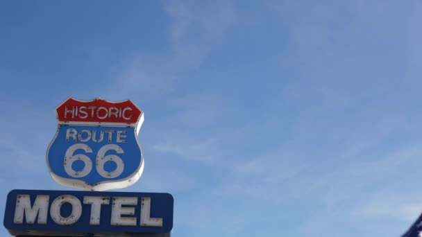 Señal de Motel retro en la histórica ruta 66 famoso destino de viaje, símbolo vintage de viaje por carretera en Estados Unidos. Icónico cartel de alojamiento en el desierto de Arizona. Señalización de neón anticuada. Bandera del Estado nacional ondeando - Metraje, vídeo