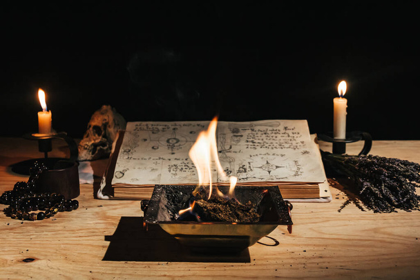 Okkultes weißes Feuerritual mit Grimoire, altem Buch, Kerzen - Foto, Bild