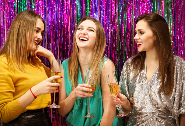 Fröhliche Freundinnen klirren mit Weingläsern und haben Spaß bei der gemeinsamen Luxusparty - Foto, Bild