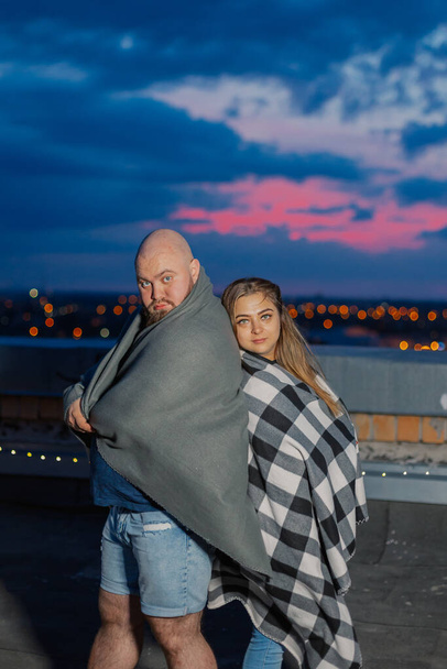 Belo casal no telhado sob um cobertor à noite. - Foto, Imagem