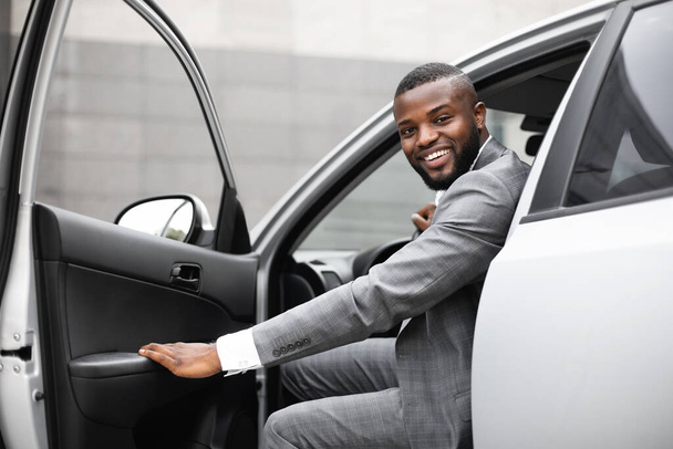 スーツ姿の黒人が車に乗る - 写真・画像