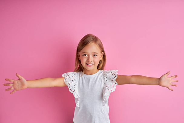 little caucasian girl want to hug everyone, spread arms at camera - 写真・画像