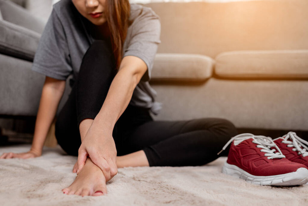 Young Asian woman massaging her pain of foot after exercise. - 写真・画像