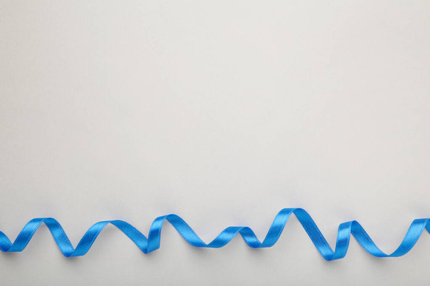 Blue ribbon on grey background with clipping path. Top view - Zdjęcie, obraz