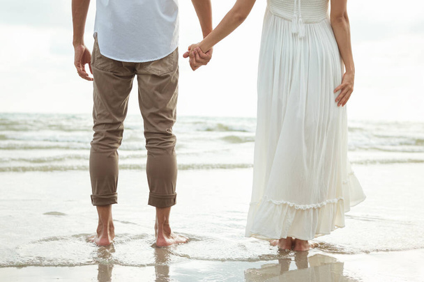 Un par de manos en la playa. Pareja romántica en la playa - Foto, imagen
