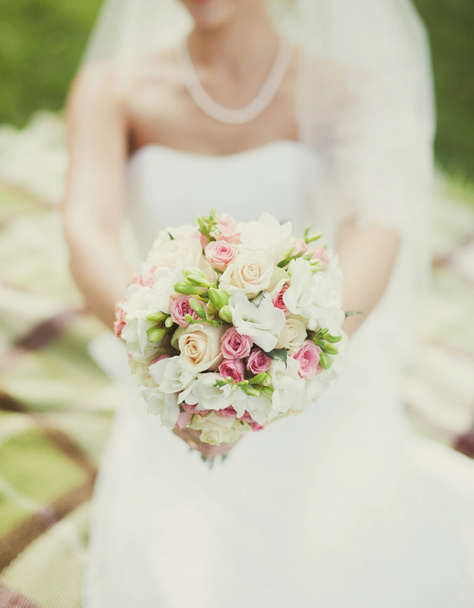 Bride in a white dress  with a bouquet - Fotó, kép