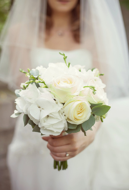 bruid in een witte jurk met een boeket - Foto, afbeelding