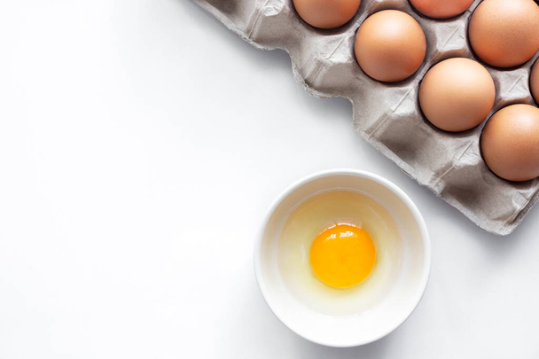 closeup of fresh chicken egg on egg box, panel, on white background with one fragile egg shell for cook for food of meal and fresh and natural egg in bowl for healthy concept - Foto, Imagem