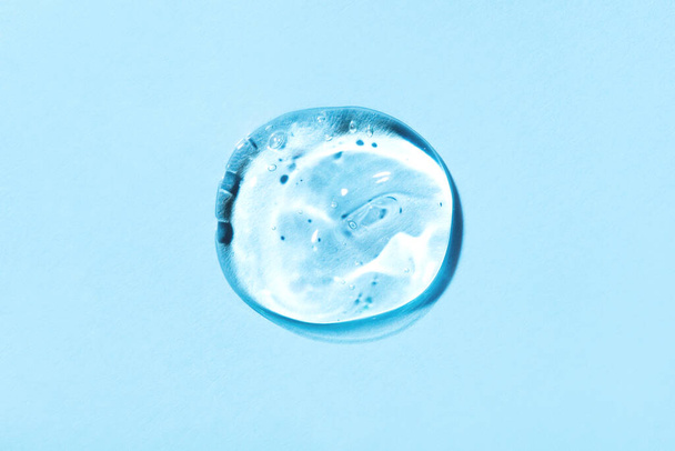 Transparent hyaluronic acid gel on a blue background. - Zdjęcie, obraz