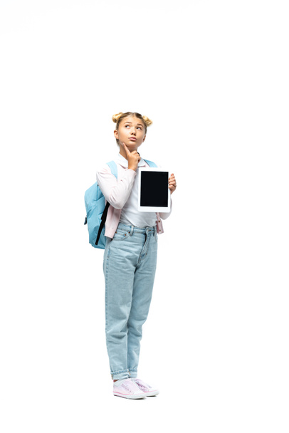 Thoughtful schoolchild holding digital tablet on white background - Photo, Image