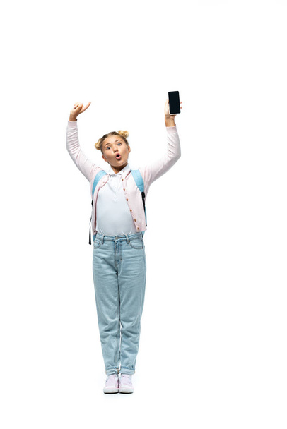 Izgalmas iskoláslány ujjal mutogatás okostelefon üres képernyő fehér háttér - Fotó, kép