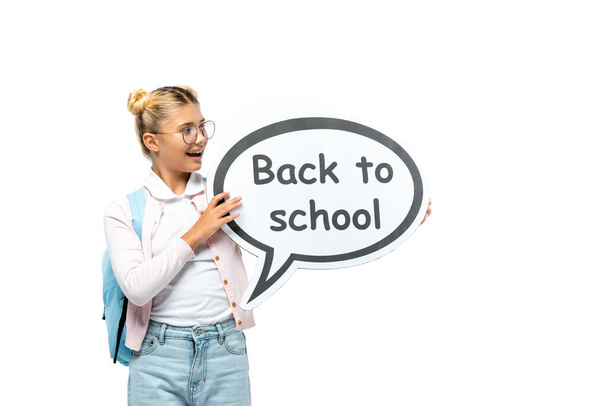 Schoolchild with backpack holding speech bubble with back to school lettering isolated on white  - Фото, зображення