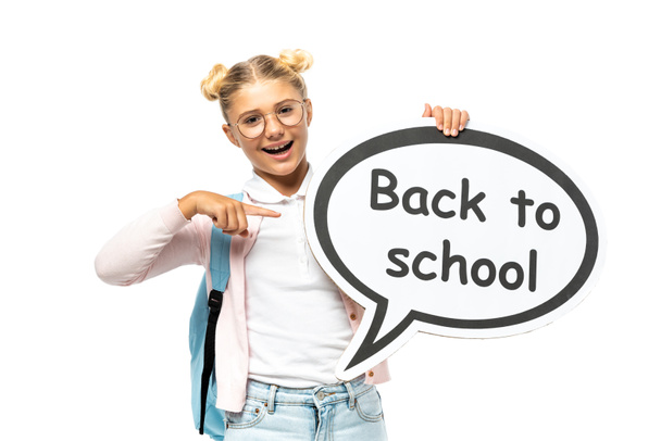 Schoolkid pointing with finger at speech bubble with back to school lettering isolated on white  - Foto, afbeelding