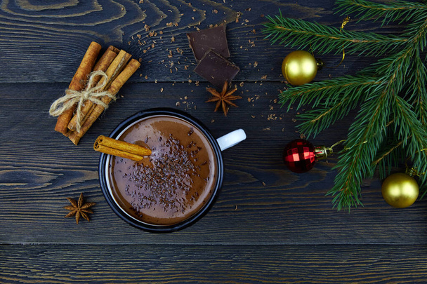 Homemade hot chocolate with cinnamon in a white enamel mug on a dark wooden background.Winter Christmas drink made from cocoa. - Foto, imagen