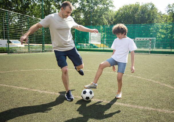 Sportif baba oğluyla futbol oynuyor. - Fotoğraf, Görsel