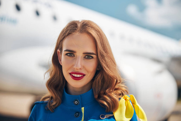 Привлекательная молодая стюардесса стоит на улице в аэропорту - Фото, изображение