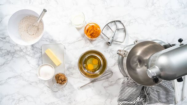 Flat lay. Ingredients to bake pumpkin spice cupcake on a marble countertop. - Photo, image