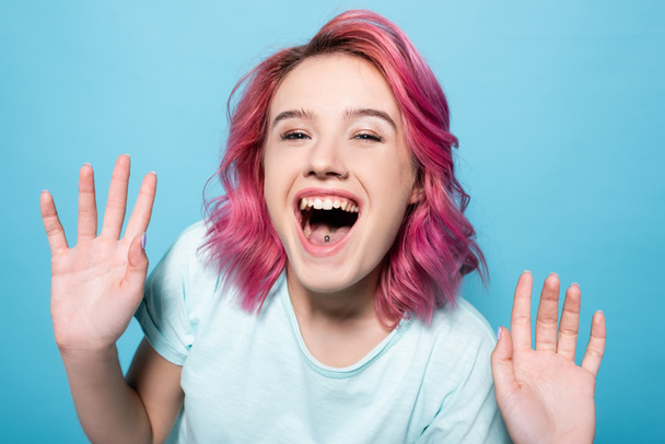fiatal nő rózsaszín haj nevet a kék háttér - Fotó, kép