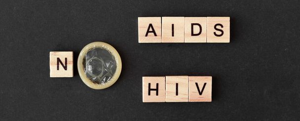 Dünya AIDS Günü. Tahta harflerle yazılmış kelimeler AIDS virüsü taşımıyor. siyah arkaplan - Fotoğraf, Görsel