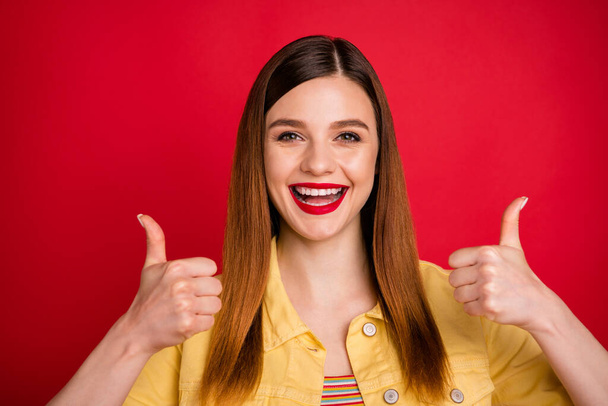 Close-up portrait of her she nice attractive lovely pretty glad content cheerful cheery red-haired girl showing two double thumbup isolated on bright vivid shine vibrant red color background - 写真・画像