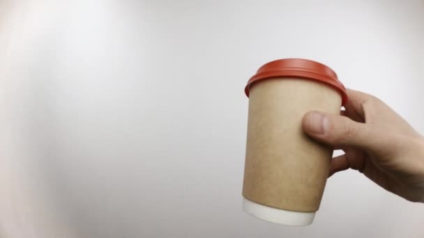 Homem está segurando xícara de café em sua mão e bebidas a partir dele no estúdio - Filmagem, Vídeo