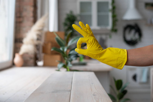 Sprzątanie, sprzątanie. Higiena i czystość. Ręka z żółtymi gumowymi rękawiczkami jest w porządku. Kciuki w górę. - Zdjęcie, obraz