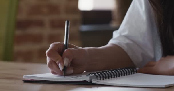 Κοντινό πλάνο του γυναικεία χέρια γραφή δοκίμιο στο σημειωματάριο - Πλάνα, βίντεο
