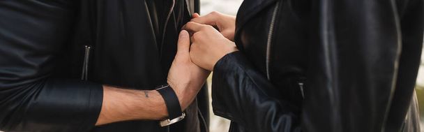 Webové stránky záhlaví mladého páru v kožených bundách drží ruce venku  - Fotografie, Obrázek