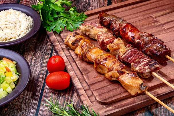 Kebab. Carne a la parrilla en una tabla de cortar, con harina y ensalada de vinagreta. - Foto, imagen