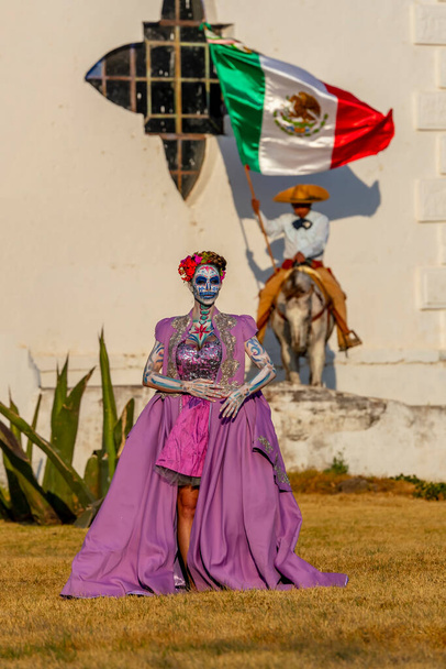 メキシコの祭りのための伝統的な頭蓋骨シュガーメイクペイントと豪華なヒスパニックブルネットモデルのポーズ. - 写真・画像