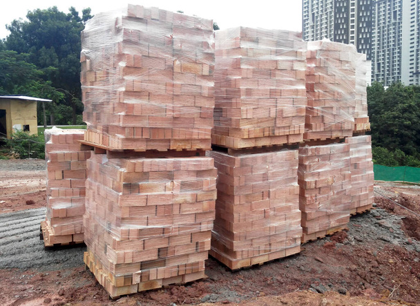 Ladrillos de arcilla almacenan paletas apiladas en el sitio de construcción. Material entregado desde la fábrica.  - Foto, imagen