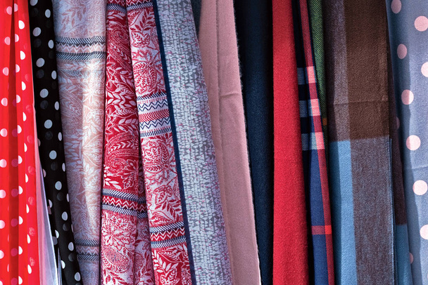 Fabrics of different types and colors hung on display - Photo, Image