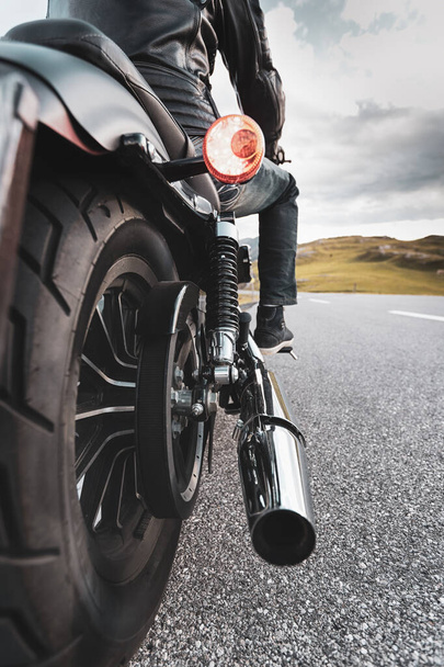 Driver riding motorcycle on an asphalt road in mountain, detail of rear wheel, close-up.front, - Fotó, kép