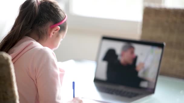家庭の概念から学校。ノートパソコンの画面から、小学校の女子生徒にレッスンを説明する先生 - 映像、動画