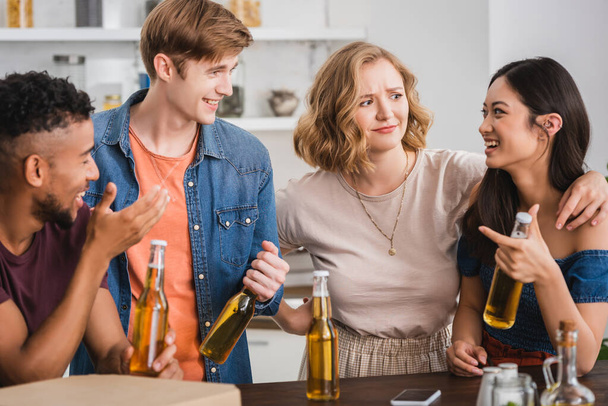 возбужденные мультикультурные друзья с бутылками пива говорить во время вечеринки - Фото, изображение