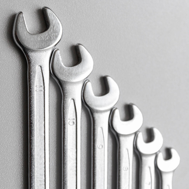 Spanners. Many wrenches. Grey background. Set of wrenches in different sizes on grey background.Square format. - Photo, Image