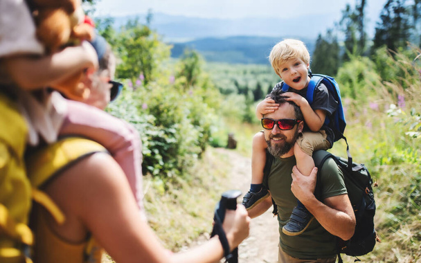 Family with small children hiking outdoors in summer nature. - Photo, image