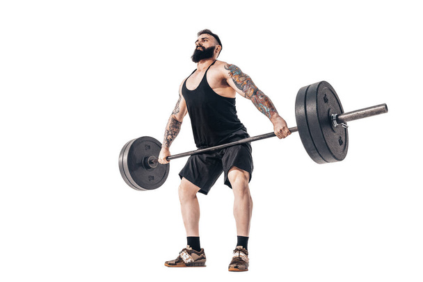 The technique of doing an exercise of deadlift with a barbell of a muscular strong tattooed bearded sports men on a white studio background. Isolate - Φωτογραφία, εικόνα