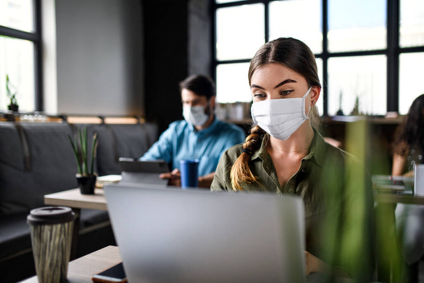 Business people with face masks indoors in office, back to work after coronavirus lockdown. - Foto, Imagem