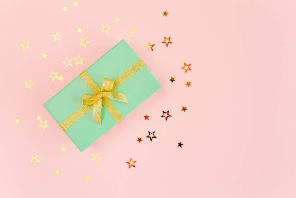 Hediye ya da hediye kutusu ve pembe arka planda yıldız konfetisi. Renkli bir kutlama, doğum günü. Noel ya da yeni yıl şablonu. Düz yatış, üst görünüm  - Fotoğraf, Görsel