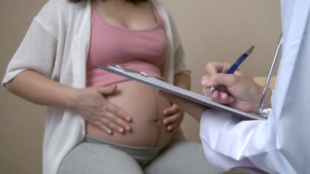 Glücklich schwangere Frauen besuchen Frauenarzt Arzt im Krankenhaus oder in der medizinischen Klinik für Schwangerschaftsberatung. Arzt untersucht Schwangerschaftsbauch auf Baby und Mutter Gesundheitsuntersuchung. Gynäkologiekonzept. - Filmmaterial, Video