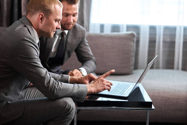 two confident business people work on laptop - Fotó, kép