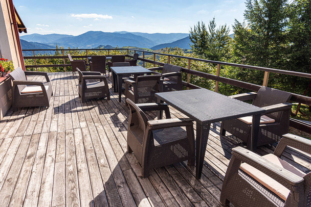 Терраса со столами и стульями с прекрасным видом на горы. Кафе терраса. - Фото, изображение