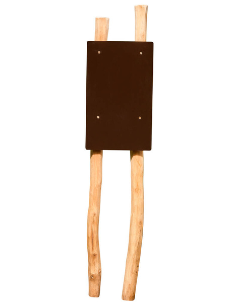 Два обработанных деревянных колья с привинченной пустой коричневой доской, изолированной на белом. - Фото, изображение