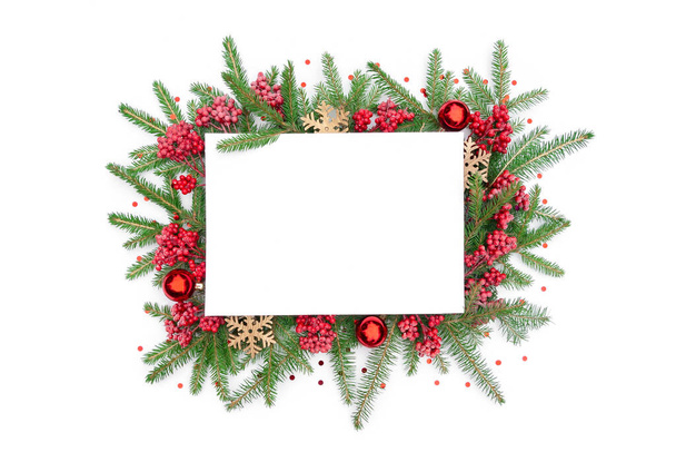 Χριστουγεννιάτικο φόντο με πλαίσιο από κλαδιά ελάτης και διακοσμήσεις χριστουγεννιάτικων δέντρων: γυάλινες μπάλες, ξύλινες νιφάδες χιονιού, μούρα viburnum και κομφετί. Χριστουγεννιάτικο πλαίσιο με αντίγραφο χώρου. - Φωτογραφία, εικόνα