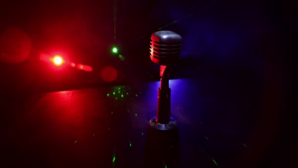 nagranie mikrofonu w ciemnym pokoju na stole ze światłem z tyłu. Skupienie selektywne - Materiał filmowy, wideo